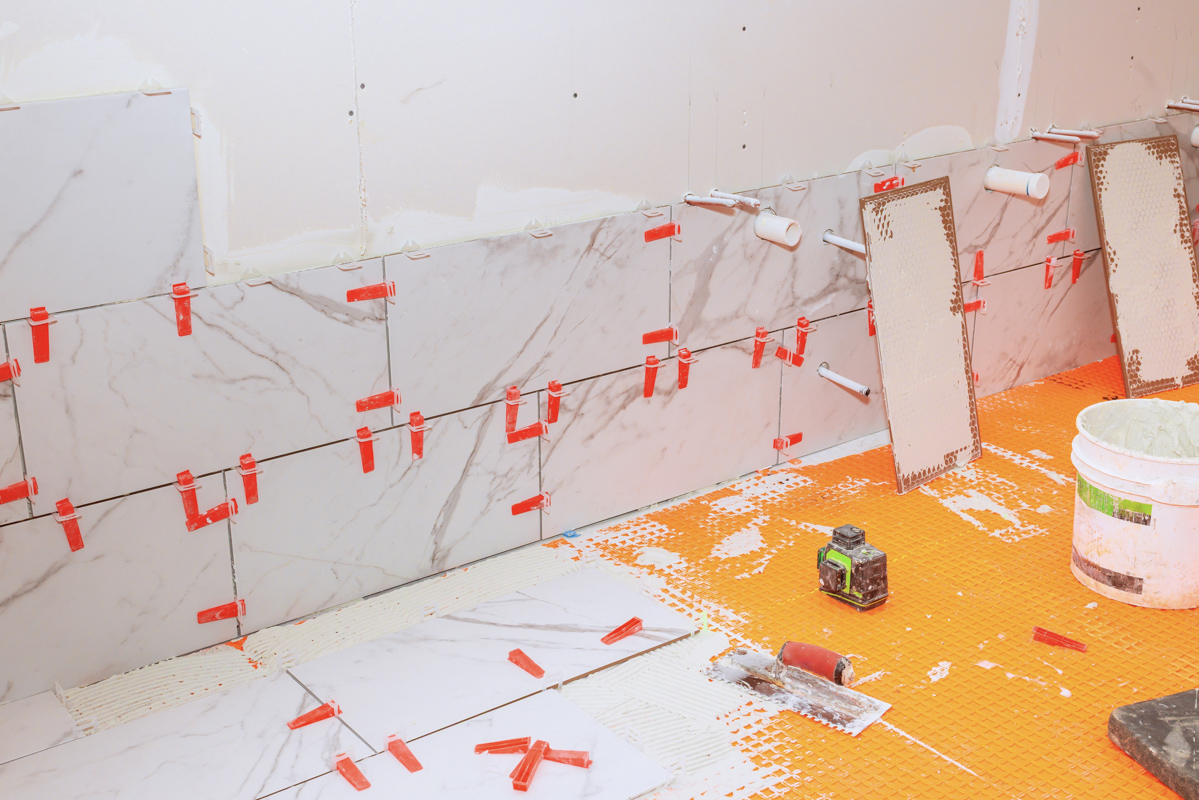 Bathroom remodel tile installation with large marble-look wall tiles