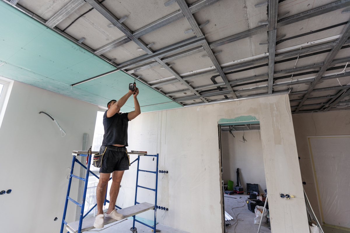 Contractor removing popcorn ceiling during home renovation