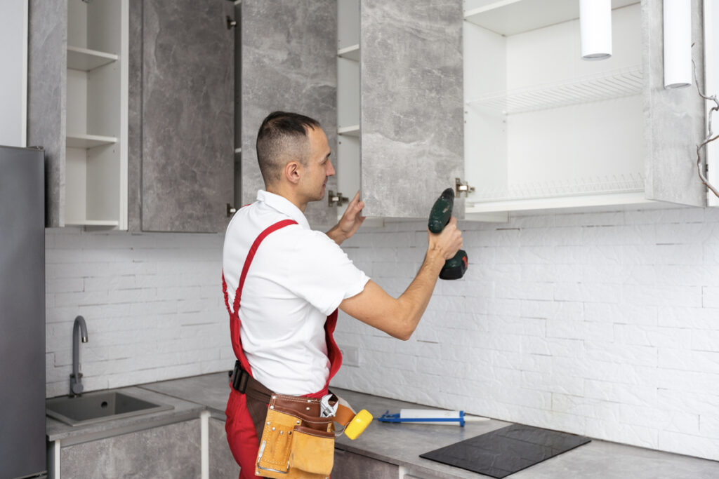 Contractor installing cabinets in modern kitchen remodel in Miami