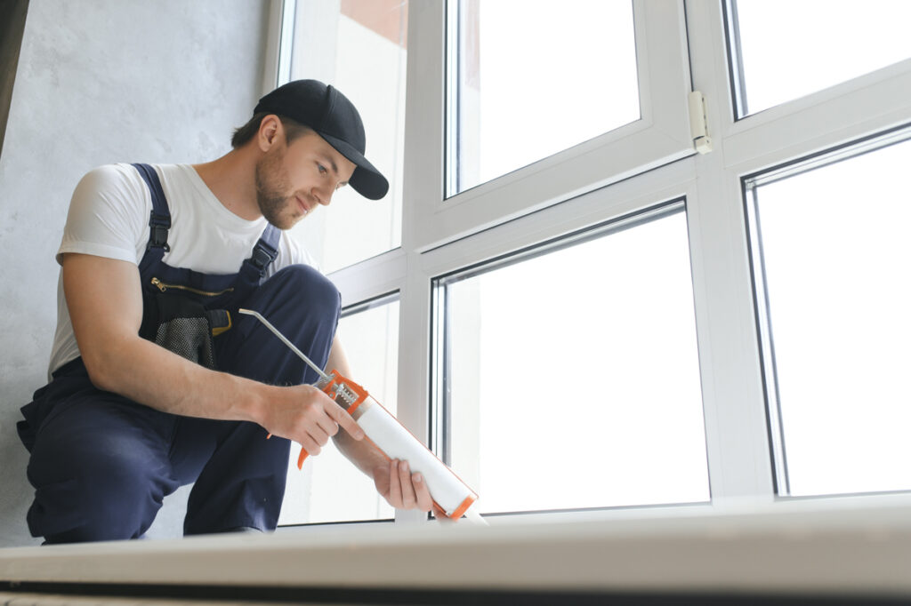 Contractor sealing a window, window replacement cost Florida