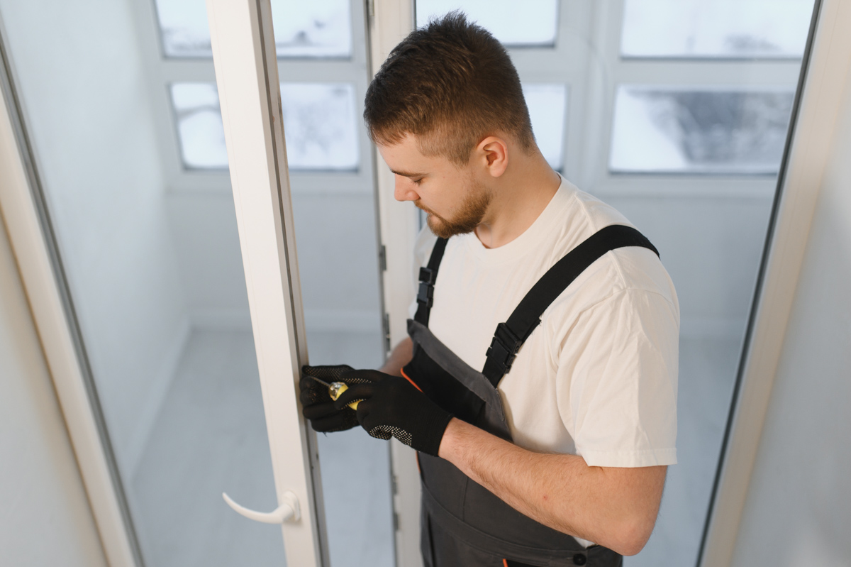 Contractor measuring window for window replacement cost estimate