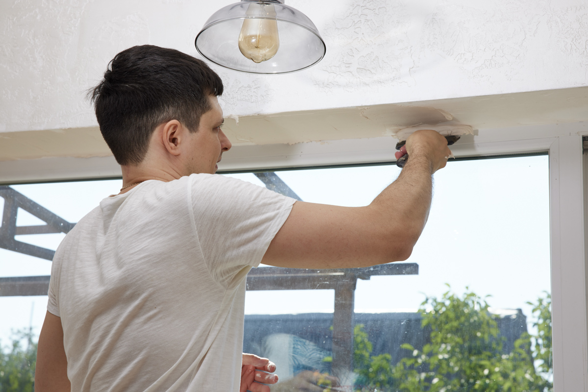 Contractor measuring sliding glass door dimensions in Florida home