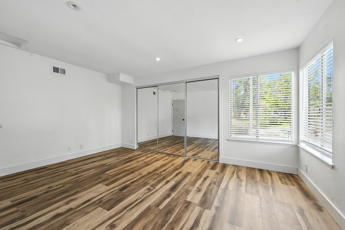 Condo remodel with mirrored closet and new wood flooring