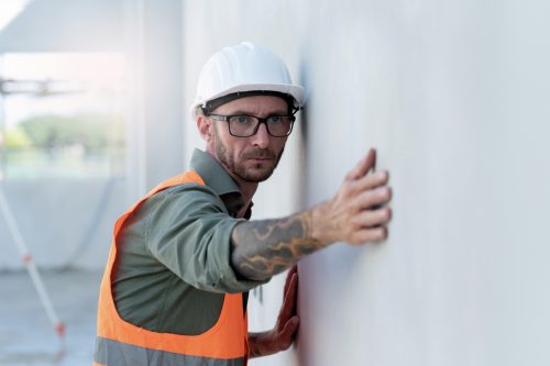 Contractor checking wall during drywall repair work