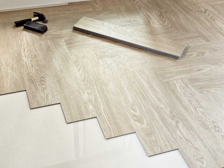 Installing vinyl plank flooring with tools and wood-look planks