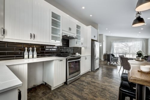 Modern kitchen with white cabinets and black tile backsplash