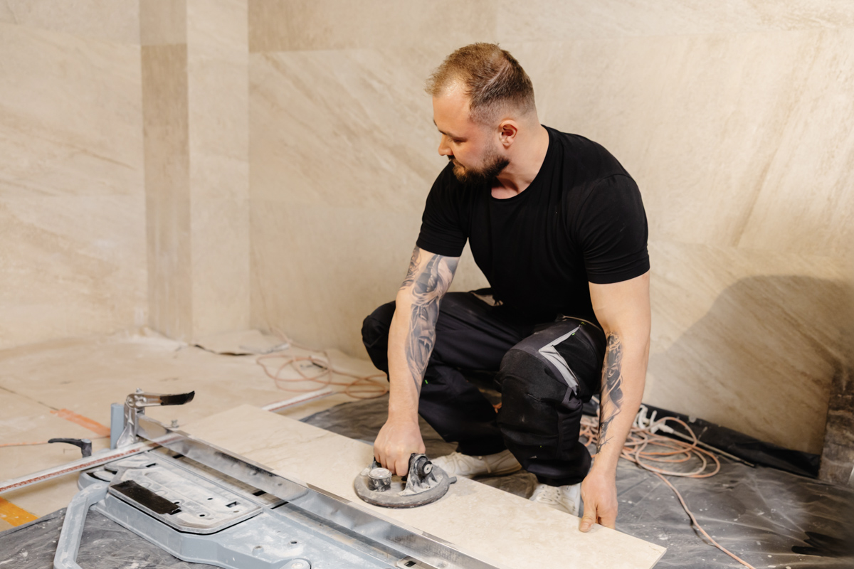 Contractor positioning floor tile for Miami bathroom vanity installation