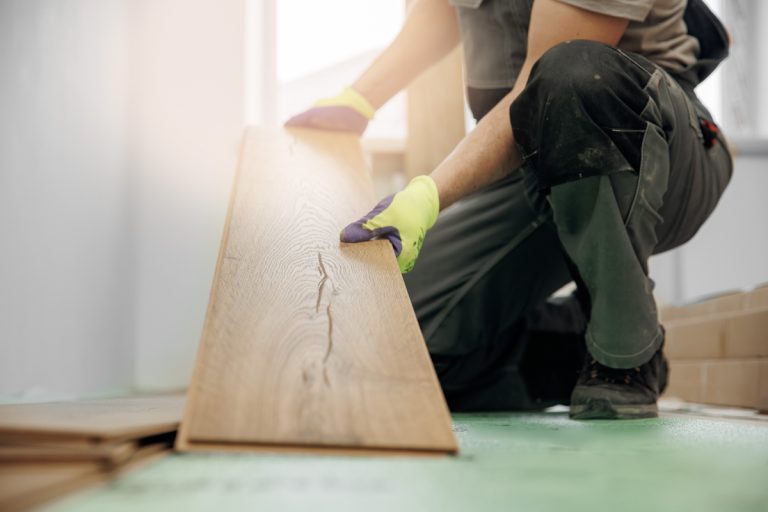 Contractor installing wood-look luxury vinyl plank flooring